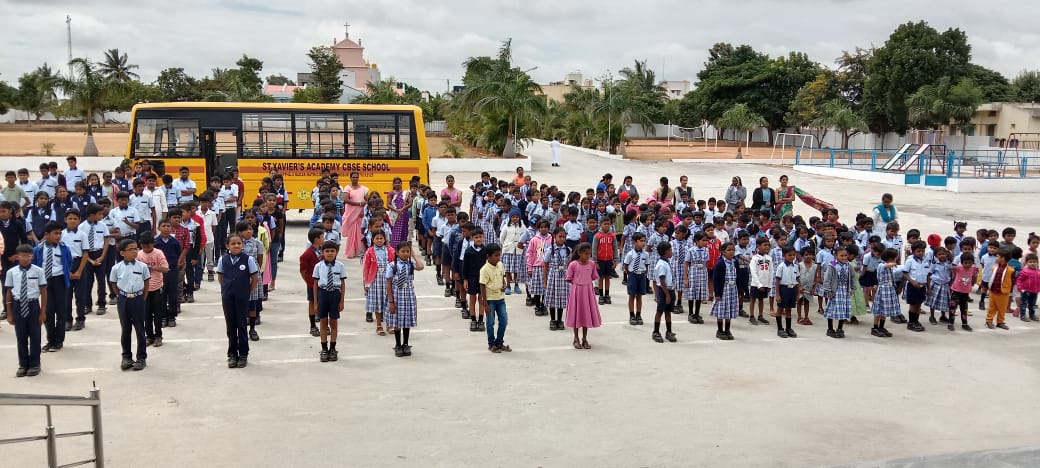 Students gathered outside St. Xavier’s Academy with their school bus in the background